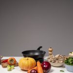 Studio composition of fresh vegetables and a frying pan, ideal for healthy cooking and recipe preparation.