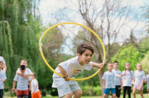 Kids enjoying a summer day playing with hula hoops in a park, showcasing friendship and fun.